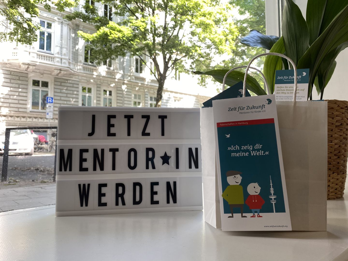 Schild im Schaufenster von Zeit für Zukunft: "Jetzt Mentor*in werden"