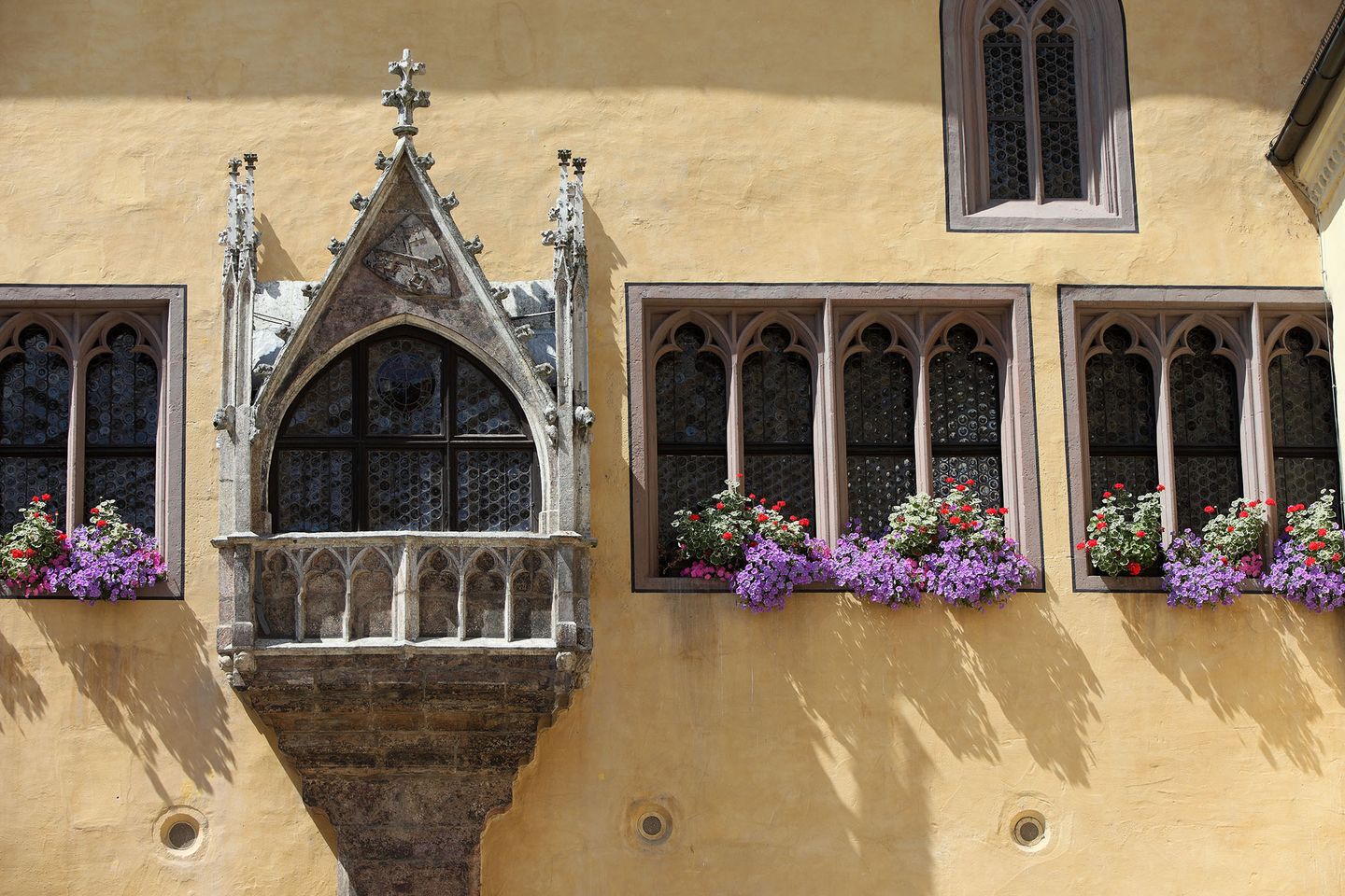 Blick auf die historischen Fenster am alten Rathaus mit bunten Blumen