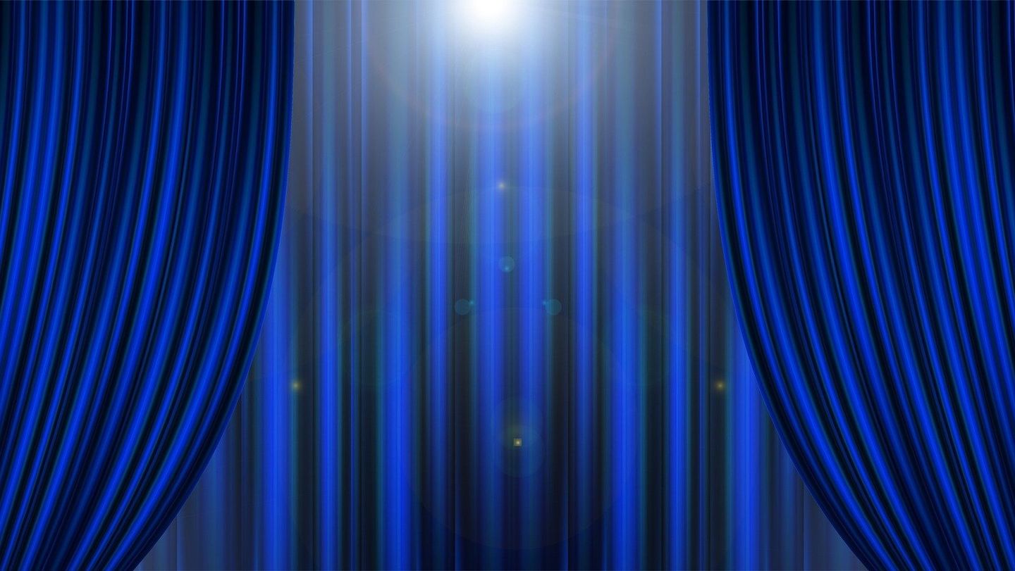 Das Bild zeigt einen blauen Vorhang eines Theaters.