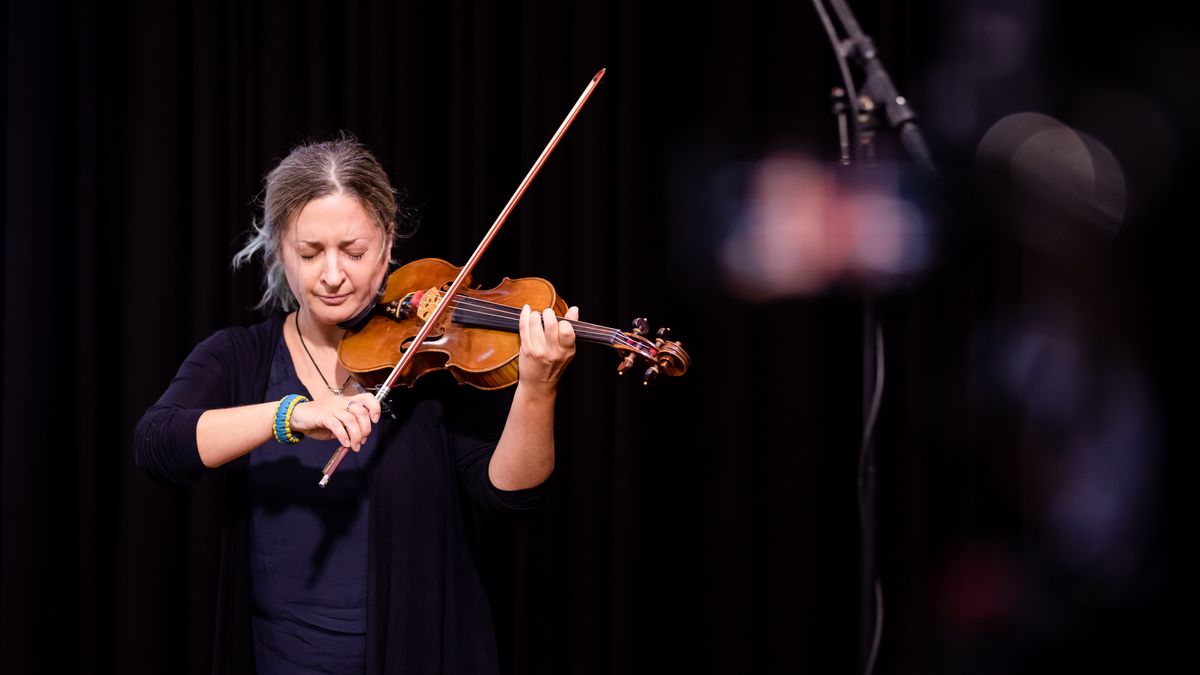 Marina Bondas spielt auf ihrer Geige. Als Armband die Farben der Ukraine, ihre Augen sind geschlossen. 
