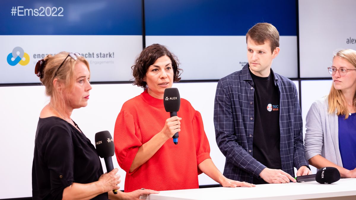 Elena Kountidou von Neue deutsche Medienmacher*innen e.V. spricht in das Mikro, links von ihr steht Prof.in Dr. Beate Küpper, rechts von ihr Markus Fleige und Henrike Schlottmann. 