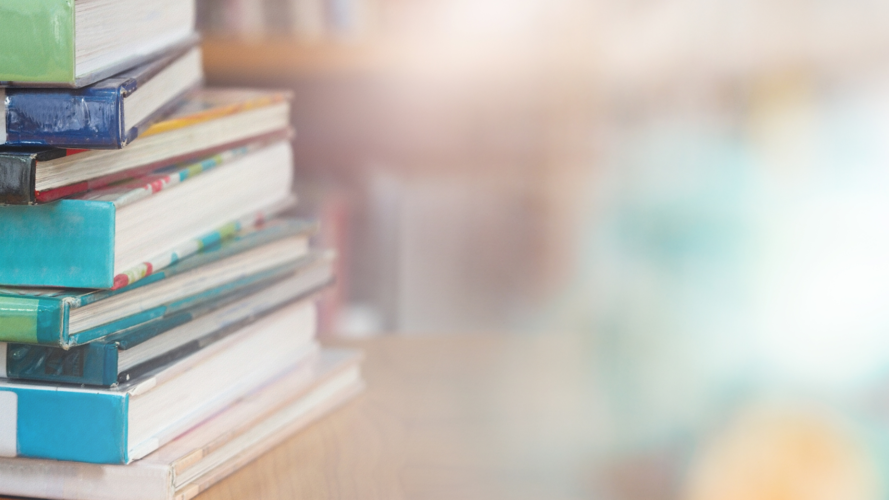 Mehrere Bücher sind auf einem Tisch gestapelt. 