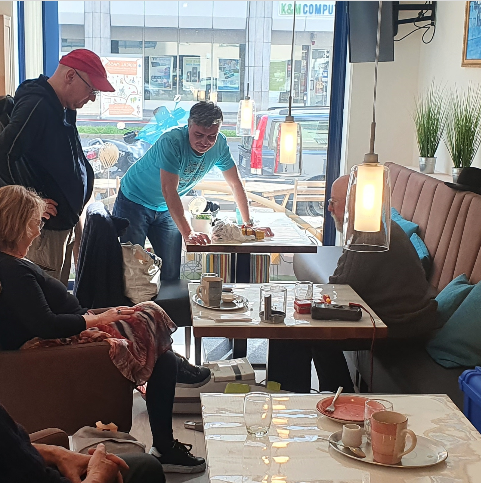 Fachlich Qualifizierte reparieren kleine Haushaltsgeräte und kommen ins Gespräch.