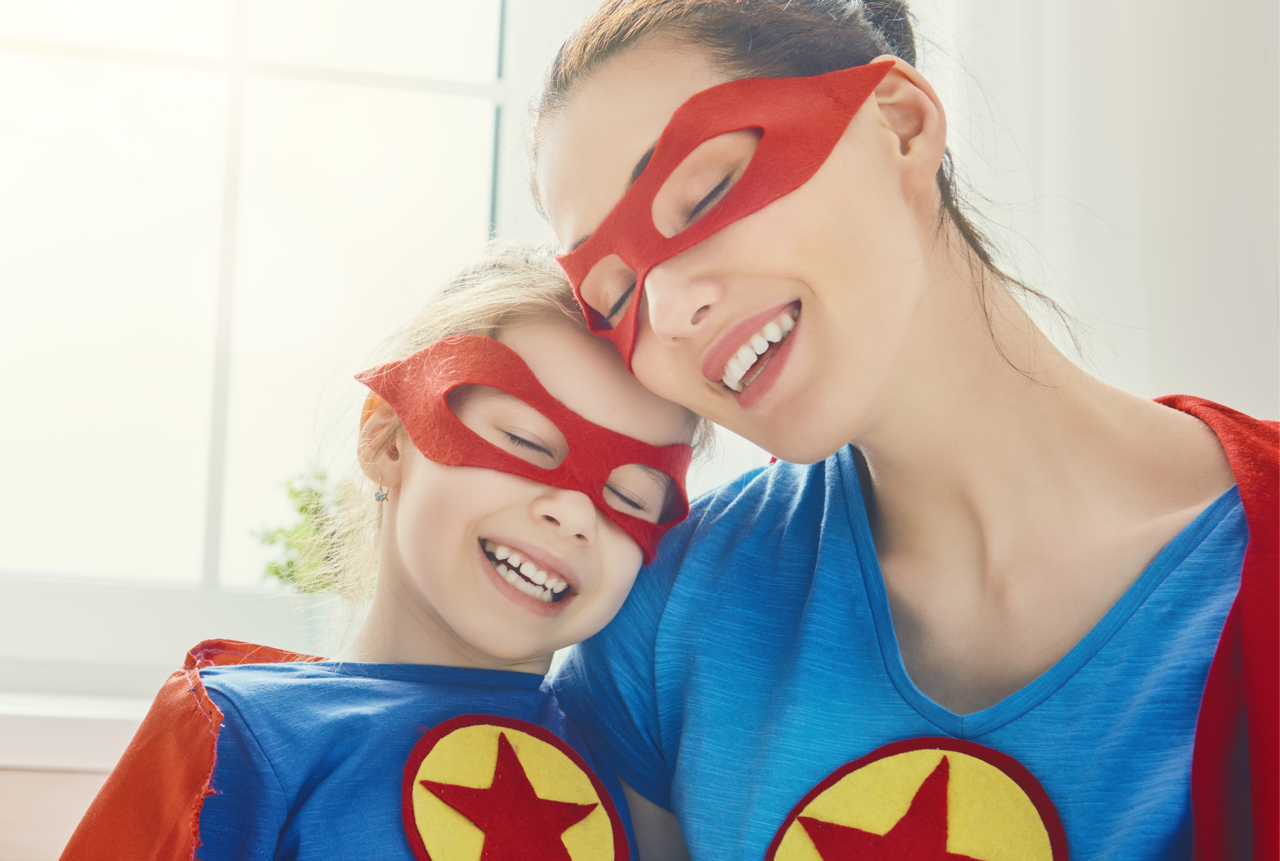 Frau und Kind im Superheldenoutfit